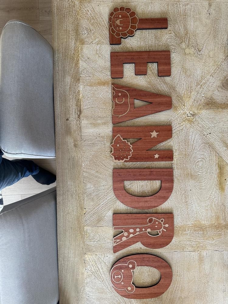 Prénom « Léandro » — lettres découpées, animaux gravés